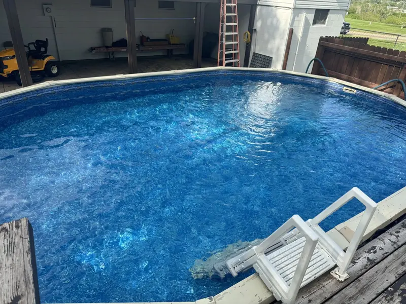 Above-ground pool with clear, balanced water and a ladder, ready to swim